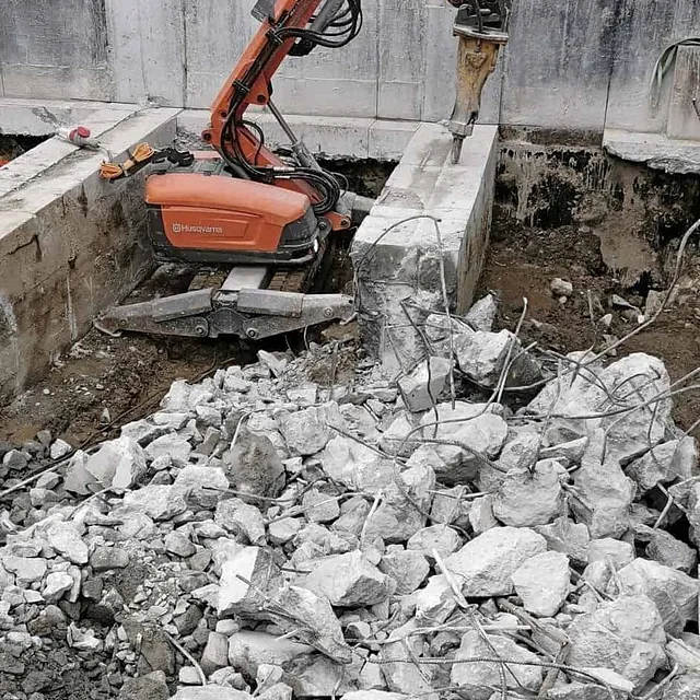 Husqvarna robotknuser i bruk med betongrester og armeringsjern rundt