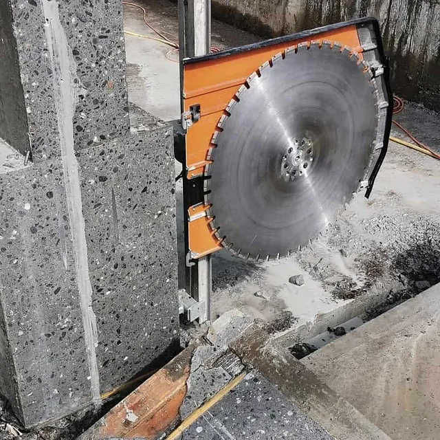Stor betongsag i aksjon med tydelige kutt i veggen